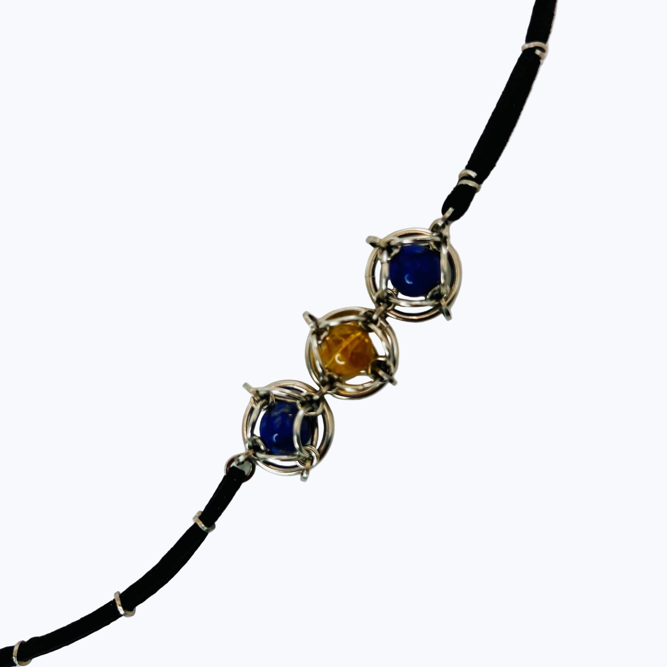 Necklace with three colored stones on a white background